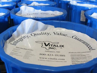 Several blue tubs are lined up, each covered with a white lid displaying "Integrity, Quality, Value... Guaranteed" and the Vitalix Inc. logo along with contact information and product details.