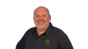 Smiling middle-aged man with short hair and a goatee, wearing a dark polo shirt with a “RALCO” logo, standing against a plain white background.