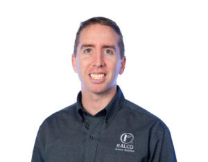 A man with short brown hair wearing a dark button-up shirt with the "RALCO Animal Nutrition" logo, smiling against a plain white background.