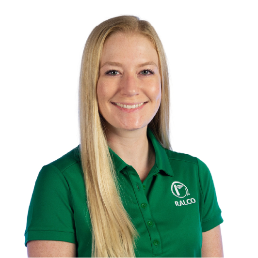 A smiling woman with long blonde hair wearing a green polo shirt with a white "RALCO" logo on it stands against a plain white background.