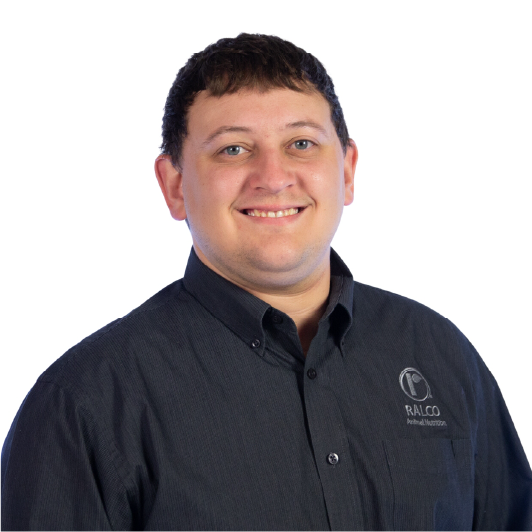 A man with short brown hair smiles at the camera, wearing a black button-up shirt with the "Ralco Animal Nutrition" logo on the chest, against a plain white background.