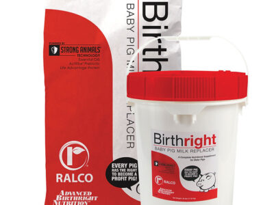 A bag and a white bucket with red lid labeled "Birthright for Swine" by Ralco are shown. The bag stands upright behind the bucket, both featuring product branding and nutritional information.