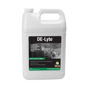 A white gallon jug labeled "DE-Lyte," featuring two piglets on the front, is a nutritional water additive for swine made by Ralco.