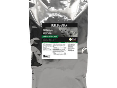 A silver bag labeled "Dual Defender," a natural swine feed supplement, features livestock images and a green-and-white information label.