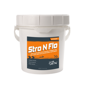 A white plastic bucket labeled "Stro N Flo" with an orange, black, and white label contains a daily supplement for pigs, goats, and cattle. The bucket features a handle and a secure lid.
